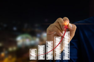 Businessman hand and pen touching virtual screen graph and arrow. Business concept investment and growth.